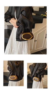 Detail of a brown leather clutch bag featuring a prominent gold curved metal handle