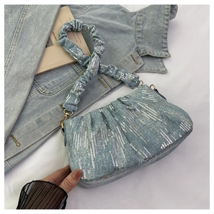 Detail of light blue denim handbag with silver sequins and ruffled scrunchie handle
