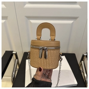 Close-up of woven cylinder mini bag with leather lid and dual silver zipper detail