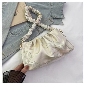 Detail of beige satin pleated handbag with pink floral embroidery and scrunchie handle