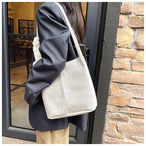 Detail of cream white pleated shoulder bag with artistic texture on premium leather