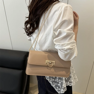 Chic beige baguette bag with golden chain and clasp in a minimalist French style
