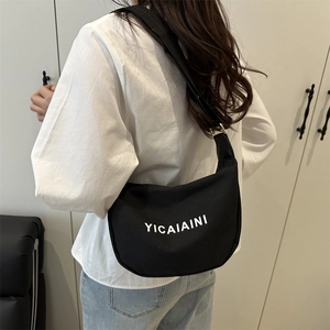 Minimalist black canvas crescent crossbody bag with white YICAIAINI print on model