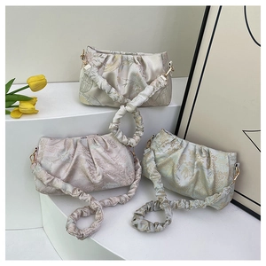 Detailed view of floral jacquard fabric on stylish ruched cloud bags in pastel colors