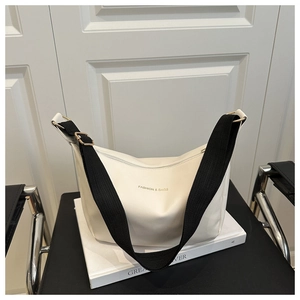 Détail du sac hobo blanc montrant la fermeture éclair et la bandoulière en nylon noir