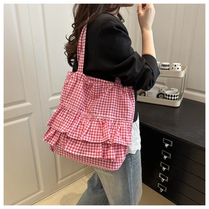 Detail of pink plaid tote bag featuring three layers of decorative ruffled lace trim