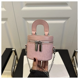 Macro view of a pale pink woven cylinder bag with a silver chain and metal dual zippers