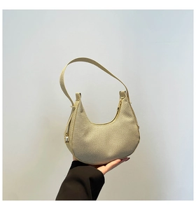 Detailed macro view of woven crescent hobo bag texture and premium gold zipper slider