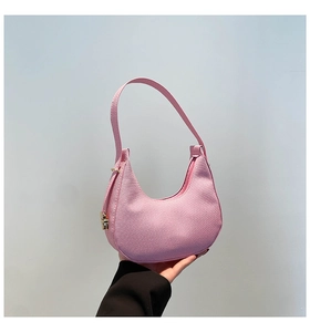 Detailed close-up of pink hobo bag featuring woven texture and gold hardware accents