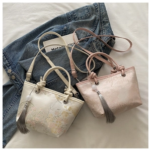 Détail de sacs seaux de style chinois avec broderie florale et pompons élégants