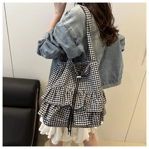 Detail of gingham tote bag with double-layered ruffles and drawstring closure
