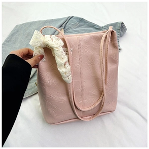 Pink tote bag detail with crinkled texture leather and white lace bow accessory