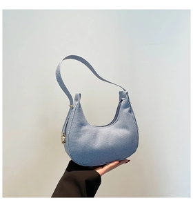 Detailed macro view of light blue hobo bag with gold zipper and woven texture fabric