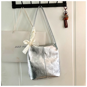 Detail of silver metallic wrinkled texture bucket bag with white lace bow decoration