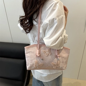 Pink lace shoulder bag with 3D butterfly embroidery and leather straps worn by model