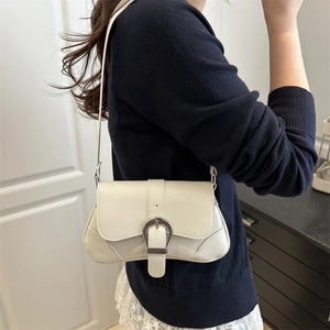 Chic off-white underarm bag with large silver buckle shown on a female model