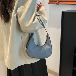 Minimalist blue denim texture hobo shoulder bag with crescent shape and gold zipper detail