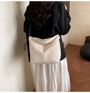 Vue arrière d'un sac cabas en nylon plissé beige avec bandoulière tissée sur mannequin