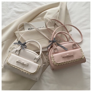 Detail kleiner Pastell-Handtaschen mit Spitzenrand, Schleifen und Karobändern auf Blazer