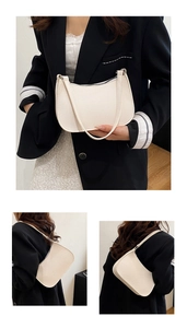 Detailed macro view of the cream-colored litchi grain texture and black zipper on the bag