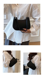 Detail view of black lychee grain crescent shoulder bag showing sleek texture and curves