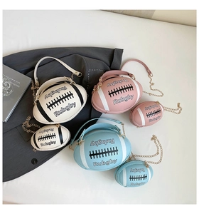 Close-up of rugby-shaped handbags in pink, white, and blue with gold chain straps