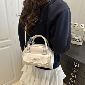 Schicke cremefarbene Schleifen-Schultertasche mit Spitze und Band am Modell gezeigt