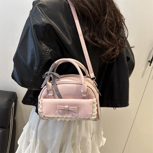 Rosa Handtasche mit Schleife, Spitzenbesatz und Karoband, stilvoll am Modell präsentiert