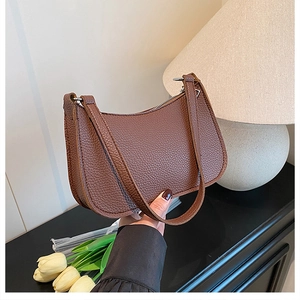 Detailed view of the brown litchi pattern leather texture on a retro underarm bag