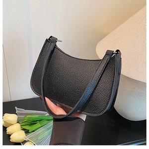 Close-up of black crescent shoulder bag with high-quality lychee grain leather texture