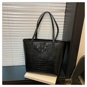 Close-up of black crocodile pattern faux leather on a large capacity tote bag
