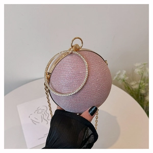 Detail of pink glitter spherical evening bag with gold rhinestone ring handle and chain