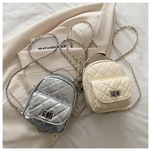 Detailed view of mini quilted bags with chain straps and metallic twist locks in silver