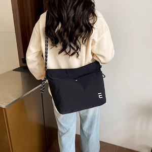 Sac bandoulière en nylon noir avec sangle tissée rayée et logo blanc pour femmes