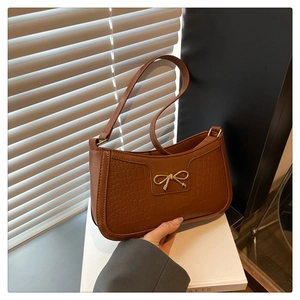 Gros plan d'un sac porté épaule marron motif crocodile avec boucle nœud en métal doré