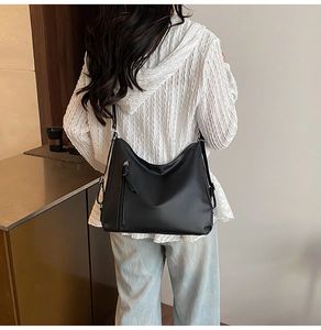 Minimalist black faux leather hobo bag featuring stylish long tassel metal zipper detail