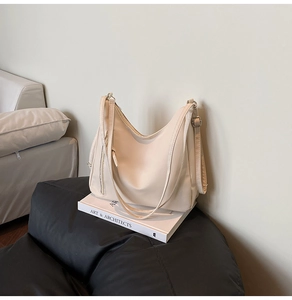 Detail of cream white large capacity hobo shoulder bag with adjustable strap and silver buckle