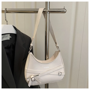Close-up of off-white hobo bag with fashion print, metal buckle and bow detail