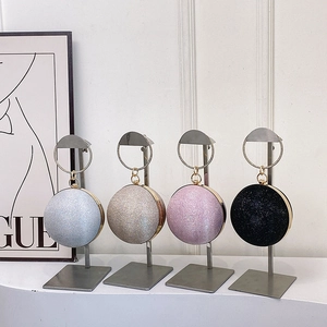 Elegant spherical evening clutch bags with ring handle and metallic finish in four colors
