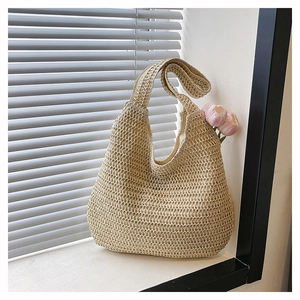 Detail of beige woven hobo bag showing intricate crochet texture and half-moon silhouette