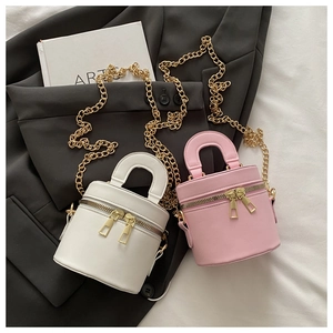 Detail of pink and white mini cylinder bags with double zippers and gold chain straps