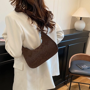 Borsa a mezzaluna motivo serpente con catena dorata su giacca bianca chic