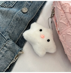 Cute white plush pig charm with silver bead chain attached to a pink quilted bag