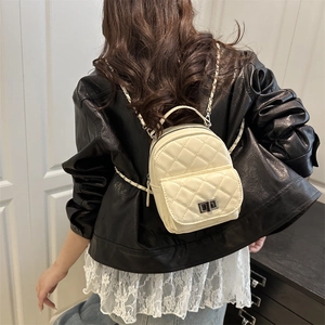 Beige quilted leather mini backpack with metal chain straps and turn-lock pocket detail