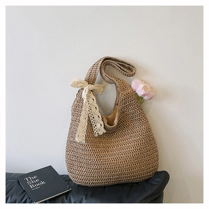 Détail du sac cabas en paille tressée avec nœud en dentelle blanche et doublure en lin
