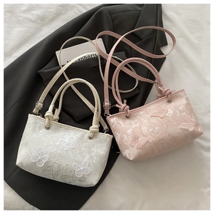 Detailed embroidery tote bags in cream and pink featuring 3D butterfly accents and straps
