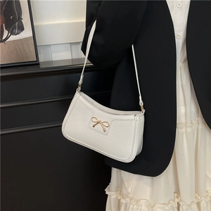 Sac sous le bras blanc en similicuir croco avec boucle nœud doré sur un mannequin