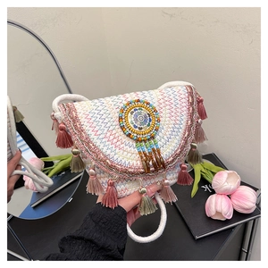 Détail du sac de selle bohème tissé avec emblème ethnique en perles et glands colorés