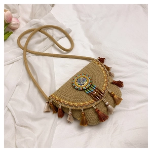 Détail du sac de selle bohème avec pompons colorés et bordures de paillettes dorées chic