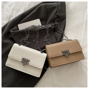 Close-up of woven texture handbags in beige and camel colors with chain straps